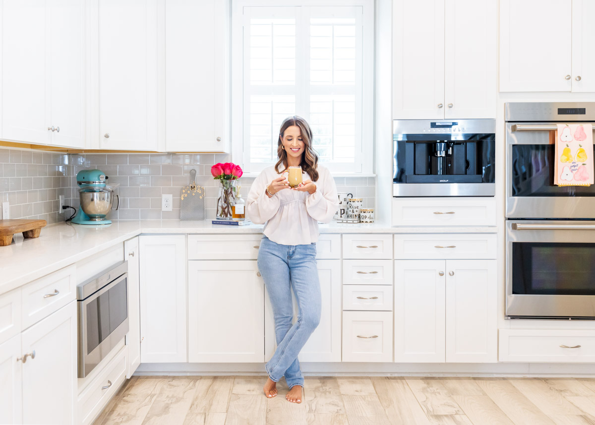 Brunette woman in jeans standing in kitchen
