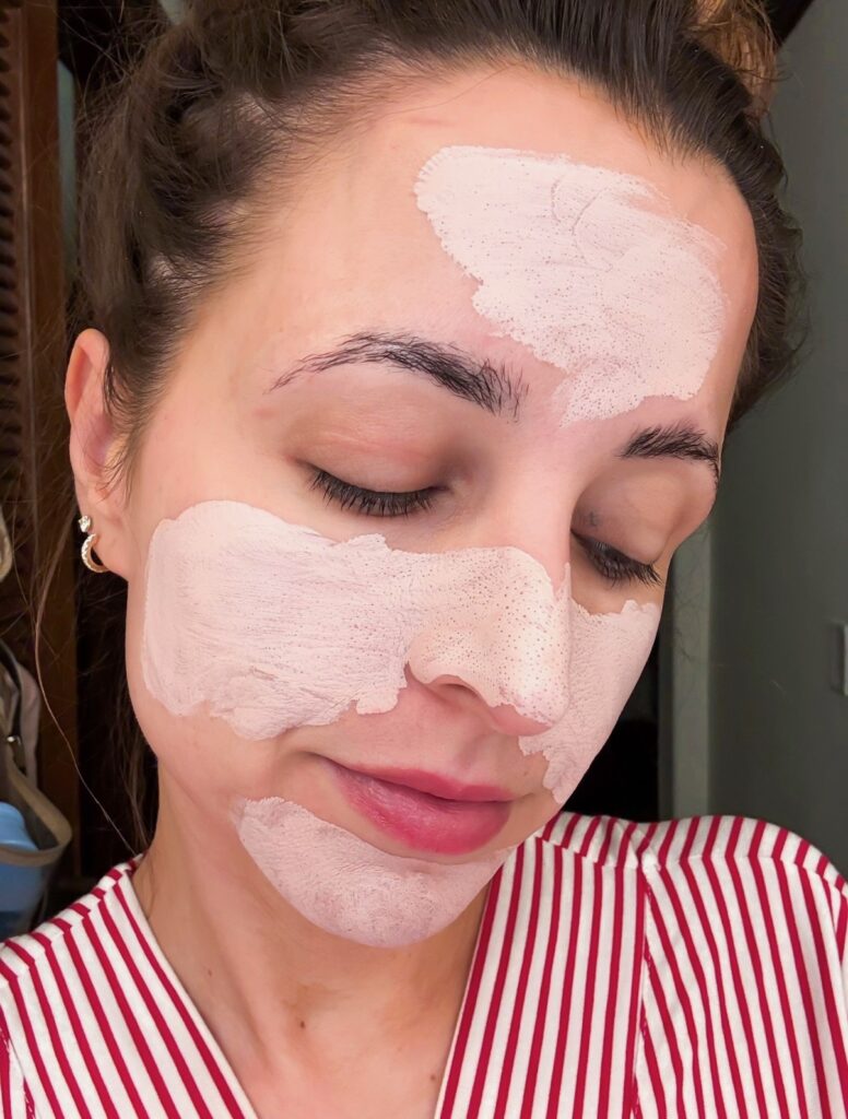 Brunette woman with clay detox mask on face