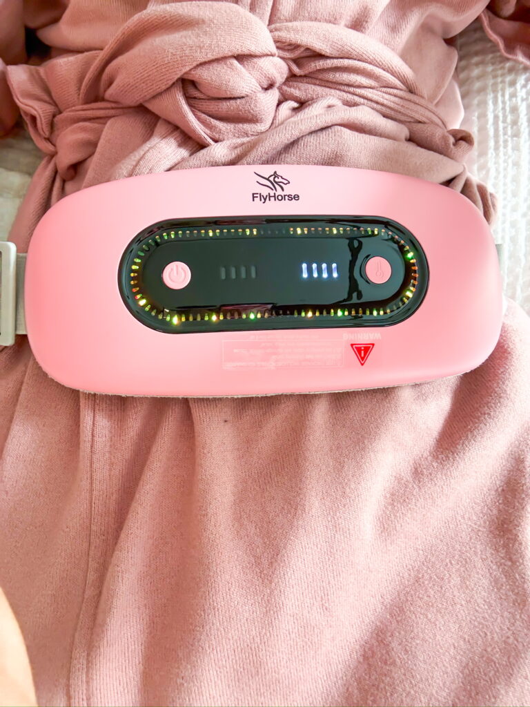 Pink chargeable heating pad on pink bathrobe as part of unsexy self-care things