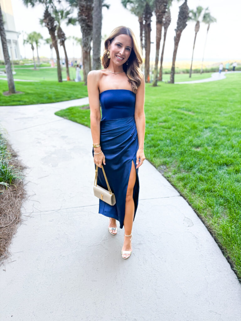woman in strapless navy blue formal midi dress with ruching and high slit
