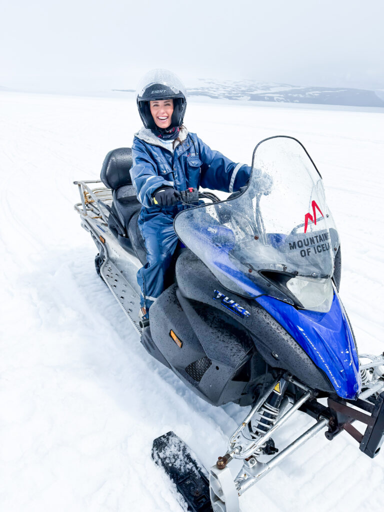 Smiling woman on a snowmobile in Iceland